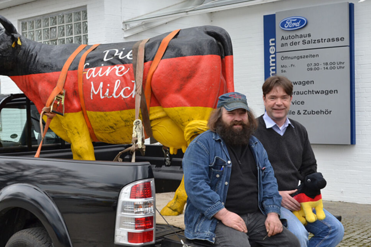 2 Männer sitzen auf der Laderampe von einem Pickup